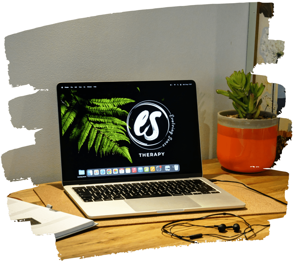 Office space of counsellor Eefje with a laptop, diary and earphones on a wooden table for online counselling.