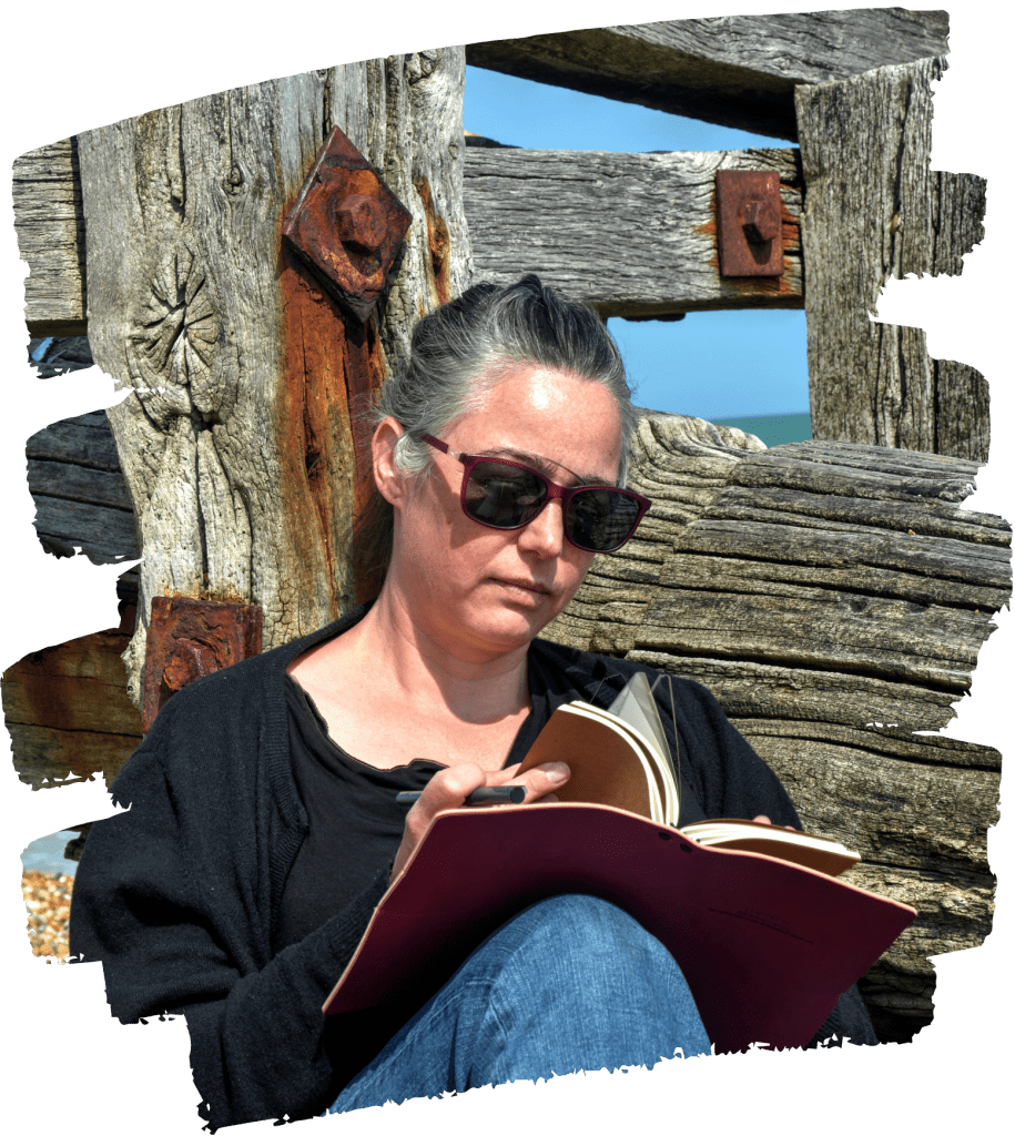 Creative therapy with counsellor Eefje can involve writing in a journal like she is doing here leaning against breakers on the beach.