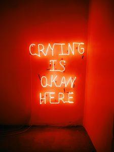 Is therapy right for me? The words written with light on the wall: crying is ok here, shows everything is ok in therapy.
