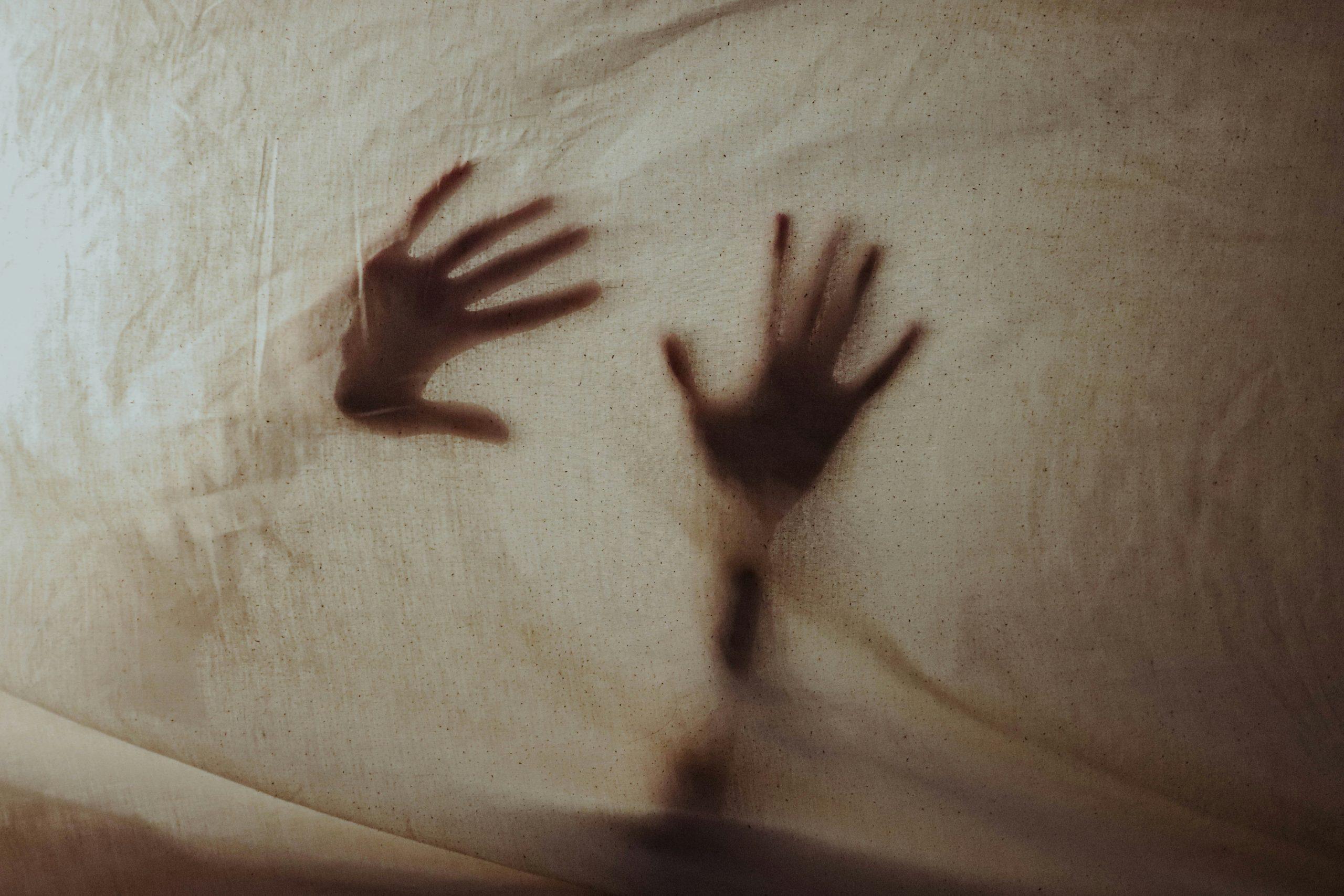 silence lives in the body represented by two hands just visible through a soft cotton cloth.